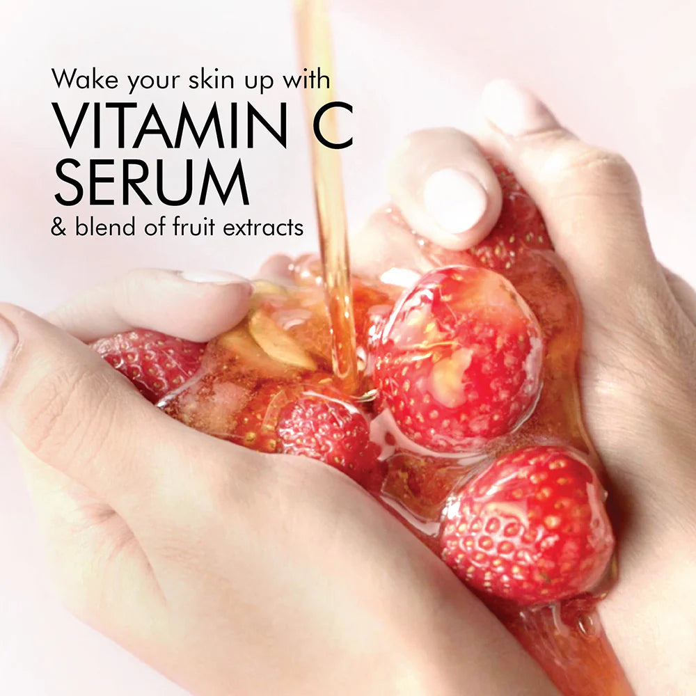 Vitamin C serum being poured over strawberries with text on a pink background