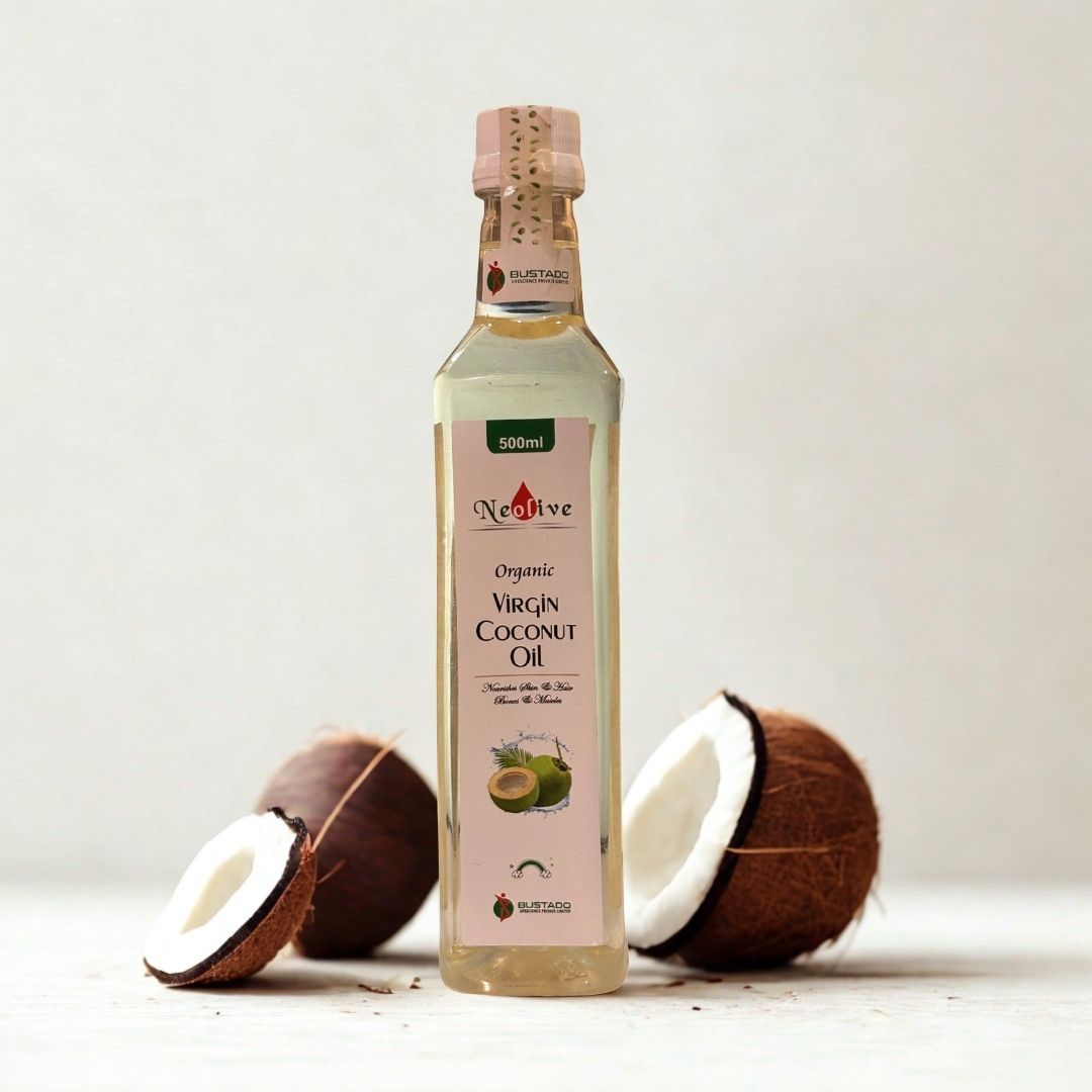 Bottle of Organic Virgin Coconut Oil with coconuts on a light background