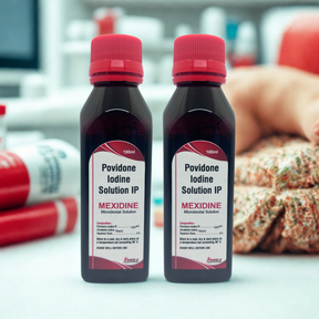 Two bottles of Povidone Iodine Solution IP labeled 'Mexidine' on a blurred background.
