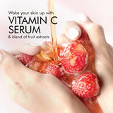 Vitamin C serum being poured over strawberries with text on a pink background