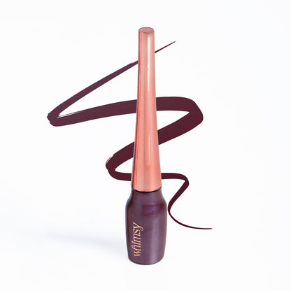 Lipstick with rose gold cap and dark purple body on a white background