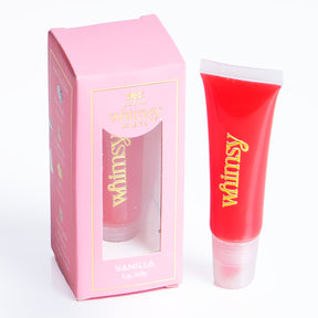 Pink lip balm tube with 'whimsy' branding next to its packaging on a white background
