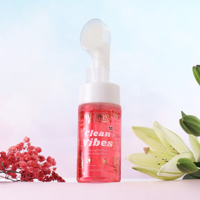Pink bottle labeled 'clean vibes' with floral elements on a light background