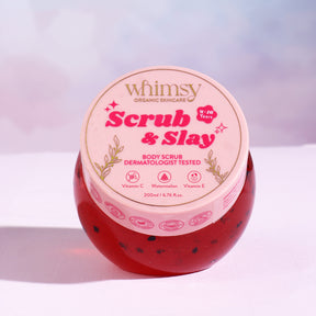 Jar of 'Scrub & Slay' body scrub with 'whimsy' branding on a light background