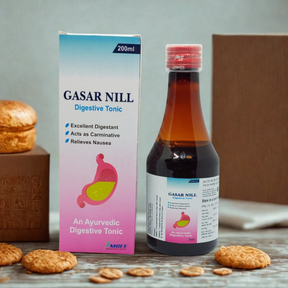 Gasar Nill Digestive Tonic bottle and packaging on a wooden surface with cookies.