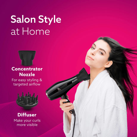 Woman using a hair dryer with concentrator nozzle and diffuser on a pink background