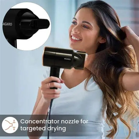 Woman using a hair dryer with a concentrator nozzle on a blurred background
